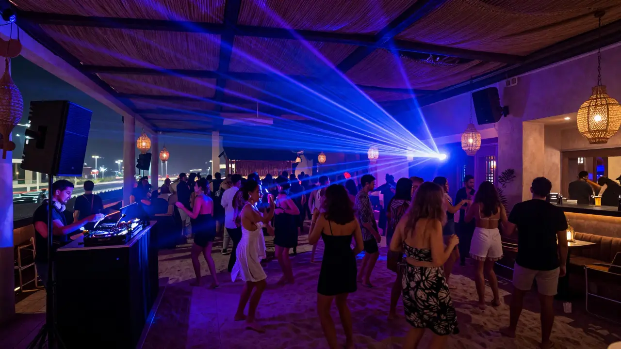 Open-air nightclub on Yas Island with crowd dancing on sand to live music under neon lights.